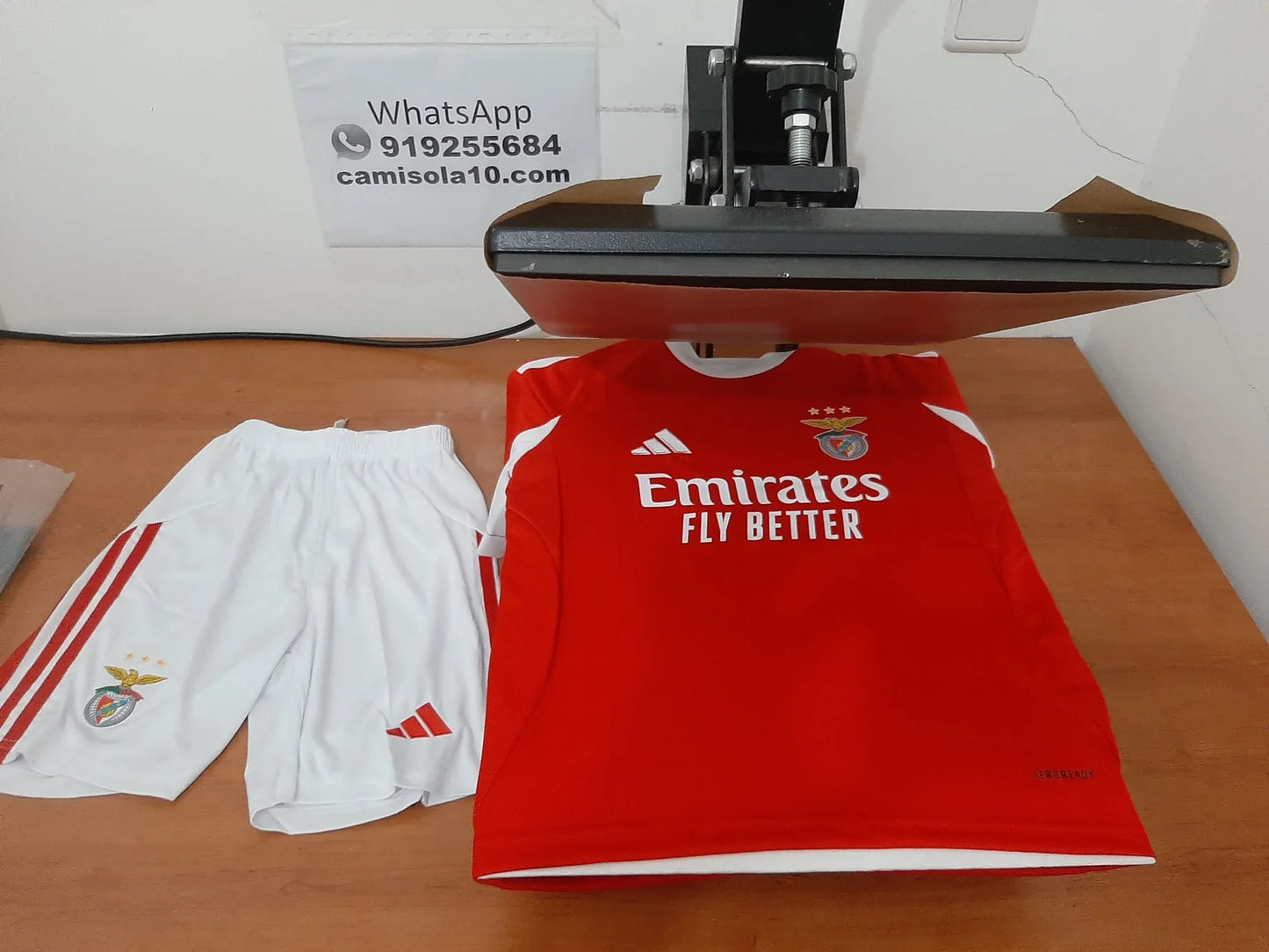 Kit de criança principal do Benfica 25/26 a ser personalizado na prensa térmica da Camisola10.