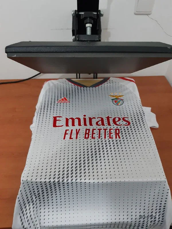 Vista frontal da camisola branca alternativa do SL Benfica 22/23 na prensa de estampagem da Camisola 10
