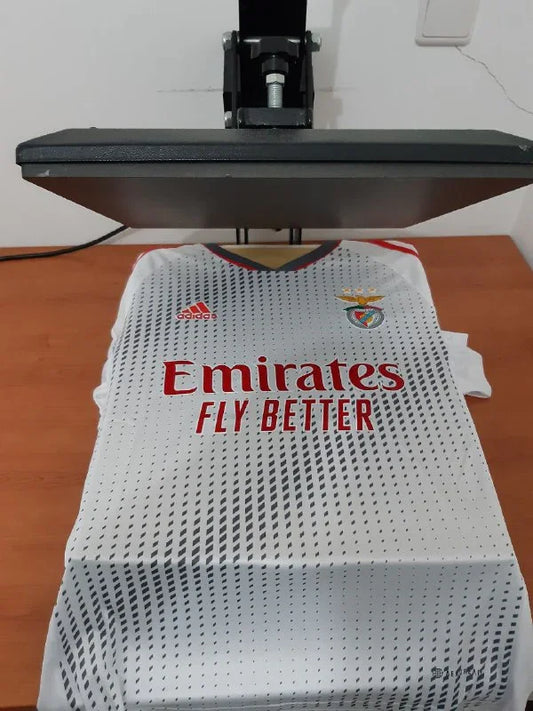 Vista frontal da camisola branca alternativa do SL Benfica 22/23 na prensa de estampagem da Camisola 10