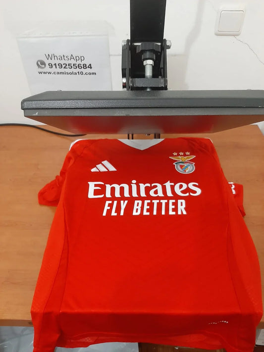 Vista frontal da camisola principal do SL Benfica 24/25 na prensa de personalização da Camisola10.