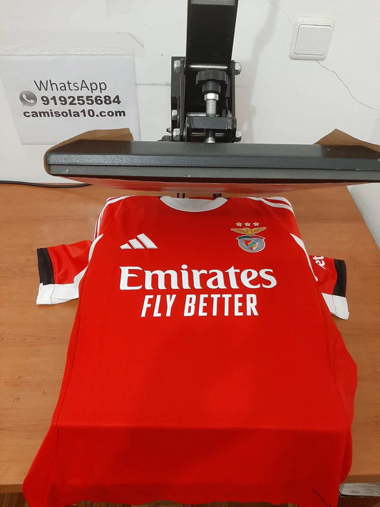 Vista frontal da camisola principal do SL Benfica 25/26 na prensa de personalização da Camisola10 