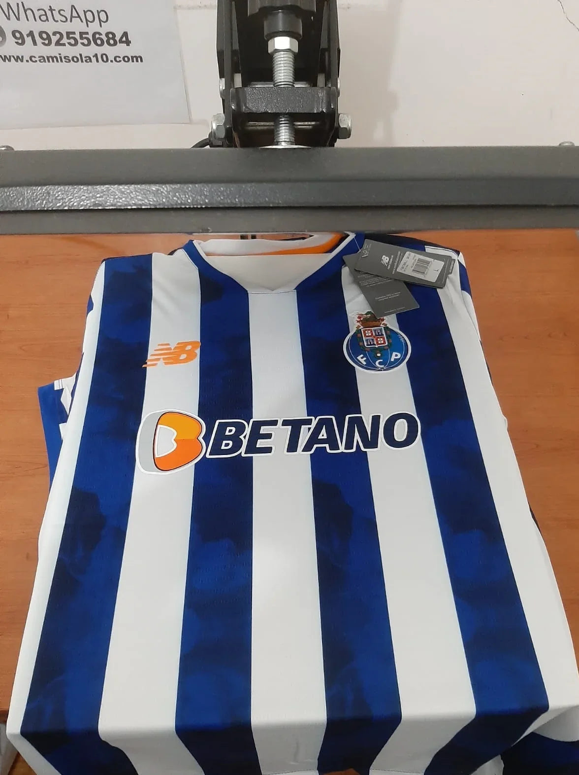 Vista frontal da camisola principal do FC Porto época 24/25 com patrocínio Betano na prensa de estampagem