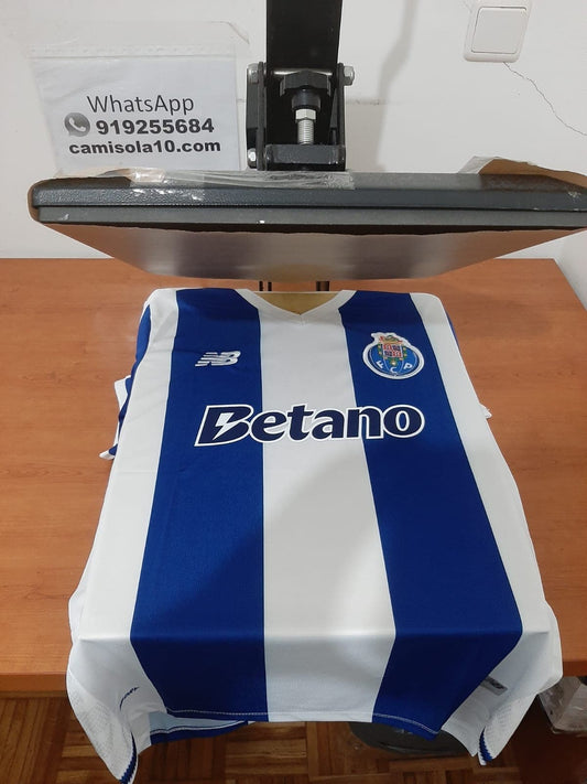 Frente da camisola principal do FC Porto 26/27 com as tradicionais riscas verticais azuis e brancas, emblema do clube e patrocinador Betano
