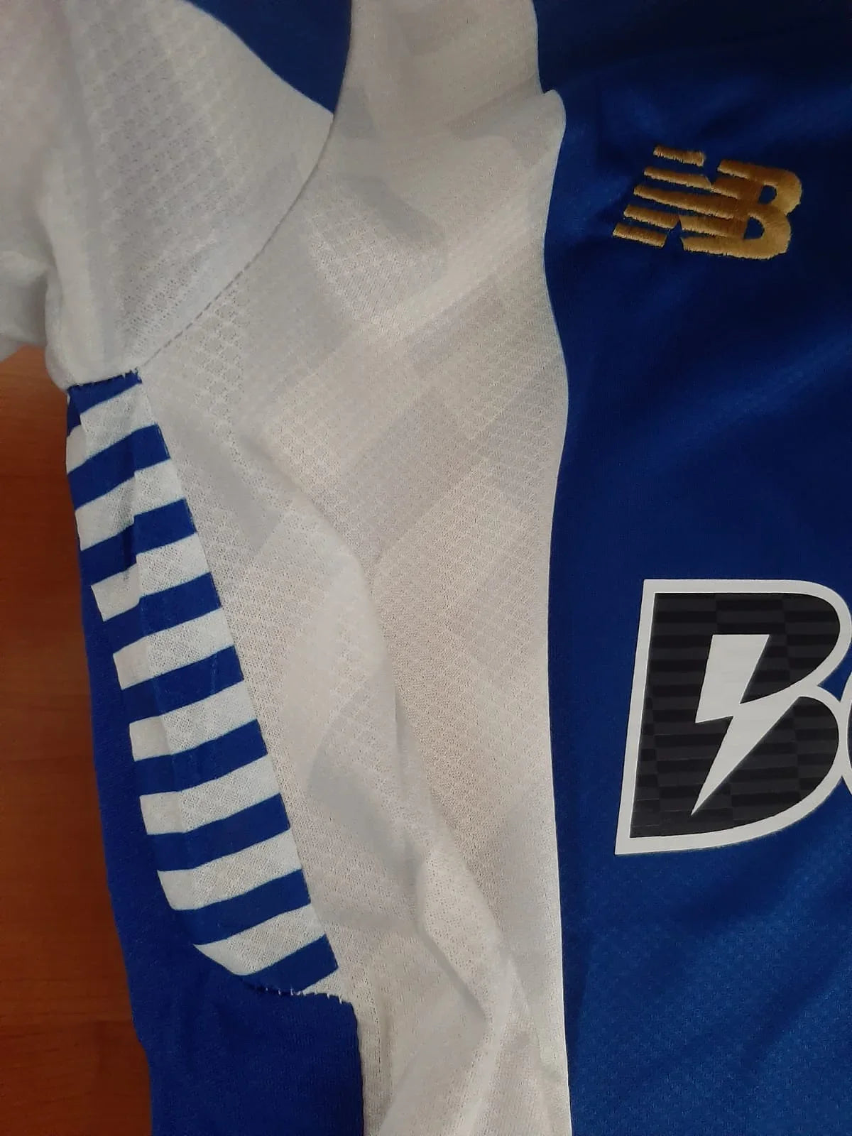 Detalhe da manga da camisola principal do FC Porto 2025/2026 com acabamento azul e branco e tecido respirável.