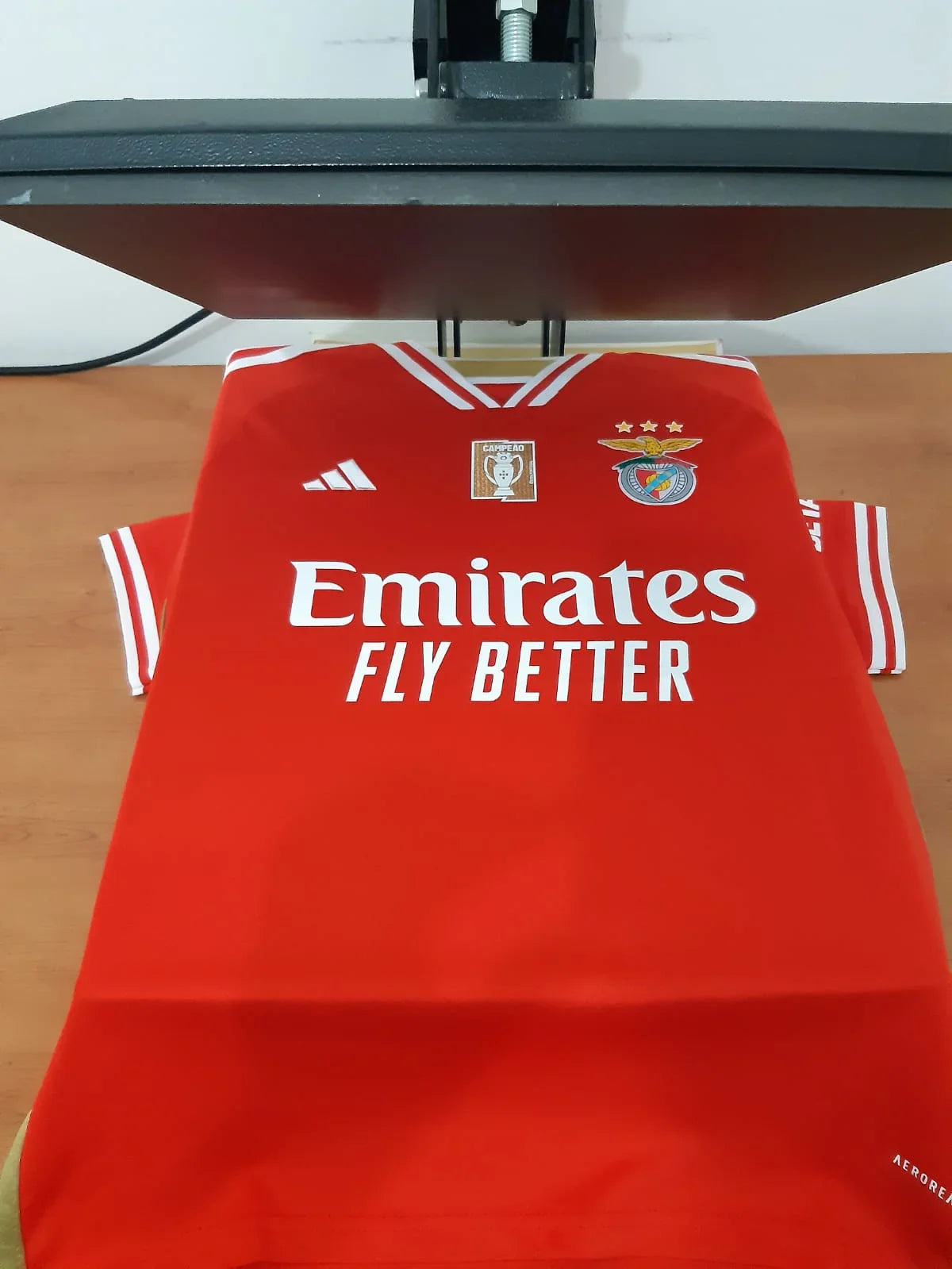 Vista frontal da camisola do Benfica 23/24 durante o processo de estampagem na Camisola 10