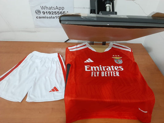 Kit de criança principal do SL Benfica 26/27 com camisola vermelha encarnada Emirates Fly Better e calções brancos