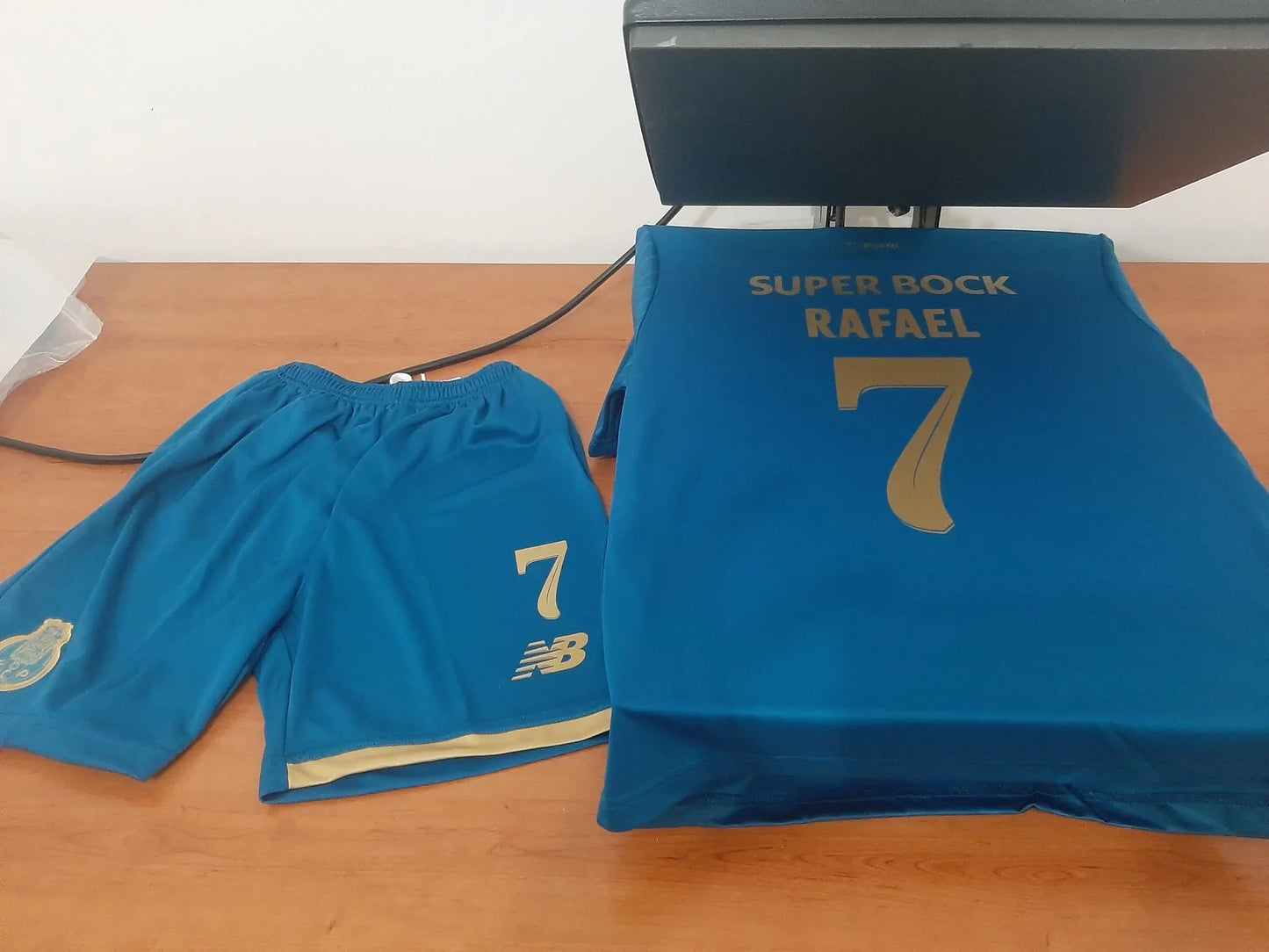 Exemplo de personalização nas costas do kit de criança do Porto com o nome RAFAEL e o número 7. 