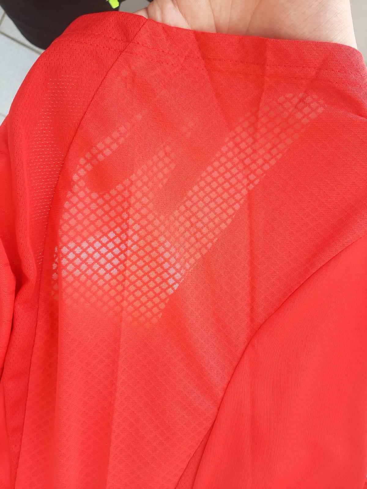 Close-up da textura do tecido respirável de alta qualidade da camisola do Benfica.